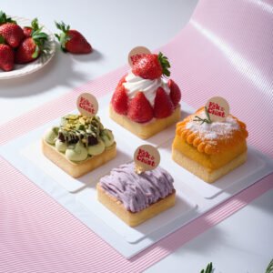 4-in-1 petite tart box with strawberry, yam, pistachio, and mango tarts on pink backdrop