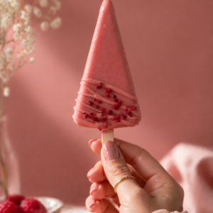 Premium Raspberry Cheesecake Cakesicle with raspberry coating and freeze-dried raspberry garnish.
