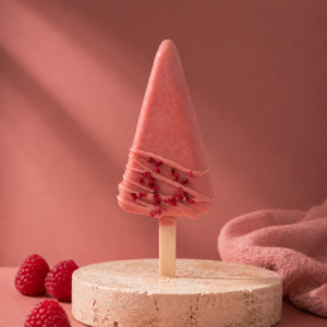 Premium Raspberry Cheesecake Cakesicle with raspberry coating and freeze-dried raspberry garnish.