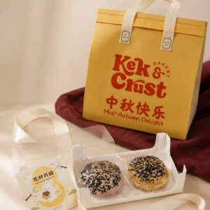 Open two-piece 3Q mooncake box with two sesame-topped mooncakes