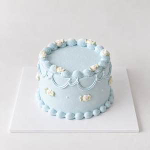 Round pastel blue vintage rose cake with ivory roses and matching blue piping