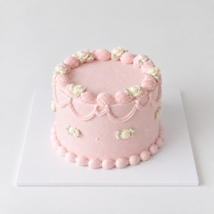 Round blush pink vintage rose cake with delicate roses, shell borders and piped garlands