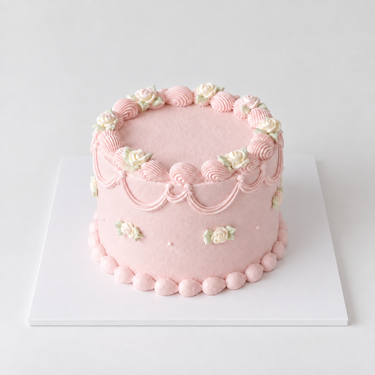 Round blush pink vintage rose cake with delicate roses, shell borders and piped garlands